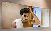 mężczyzna przed lustrem ogląda swoje włosy